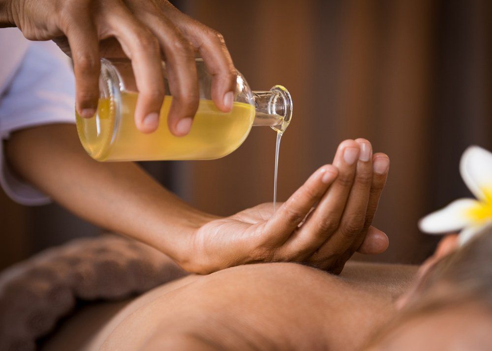 Therapist Pouring Massage Oil at Spa — North Miami Beach, FL — Oriental Massage &Spa