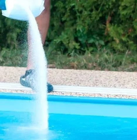 Una persona está echando sal en una piscina.