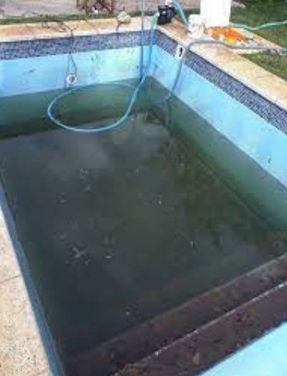 Una piscina con una manguera atada a un costado.