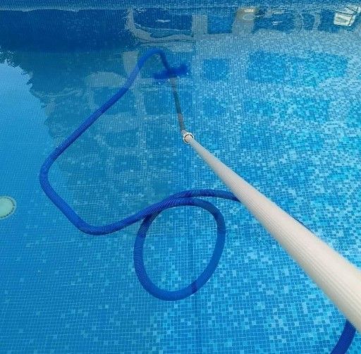 Una manguera azul está unida a un poste en una piscina.