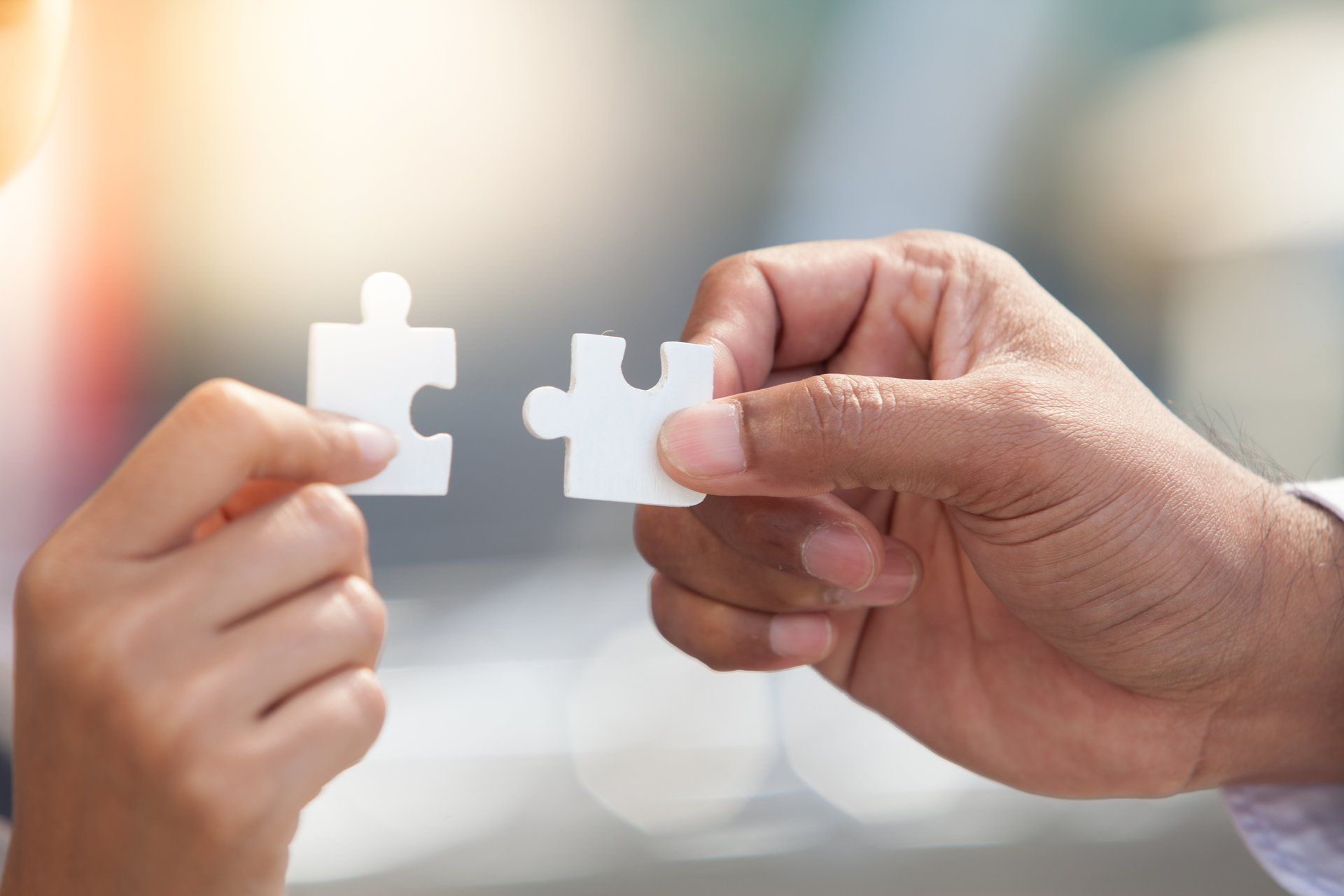 Ein Mann und eine Frau halten zwei Puzzleteile in ihren Händen.