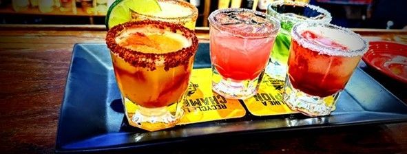 A tray of four different types of drinks on a table.