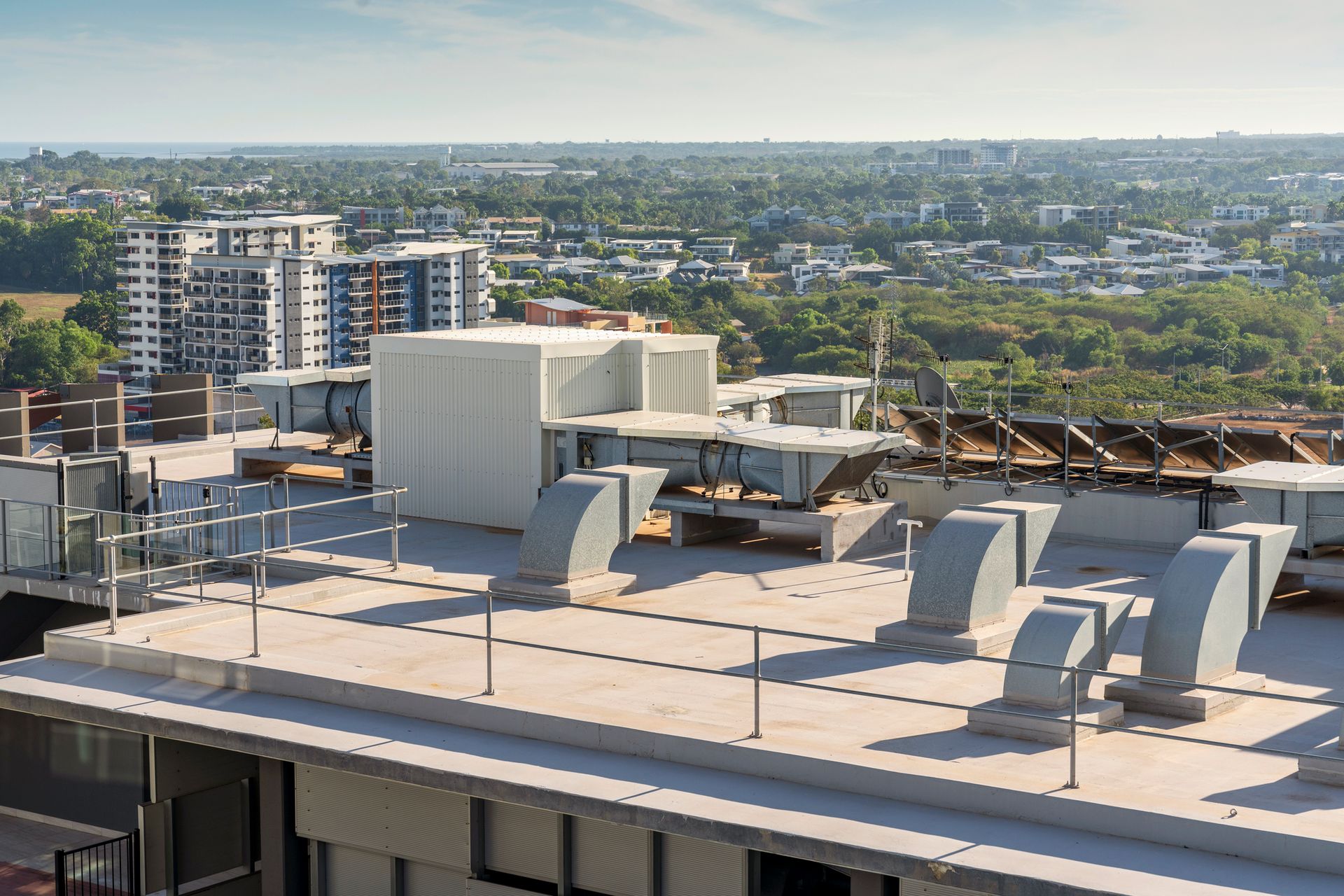 An aerial view of the roof of a building with a city in the background.