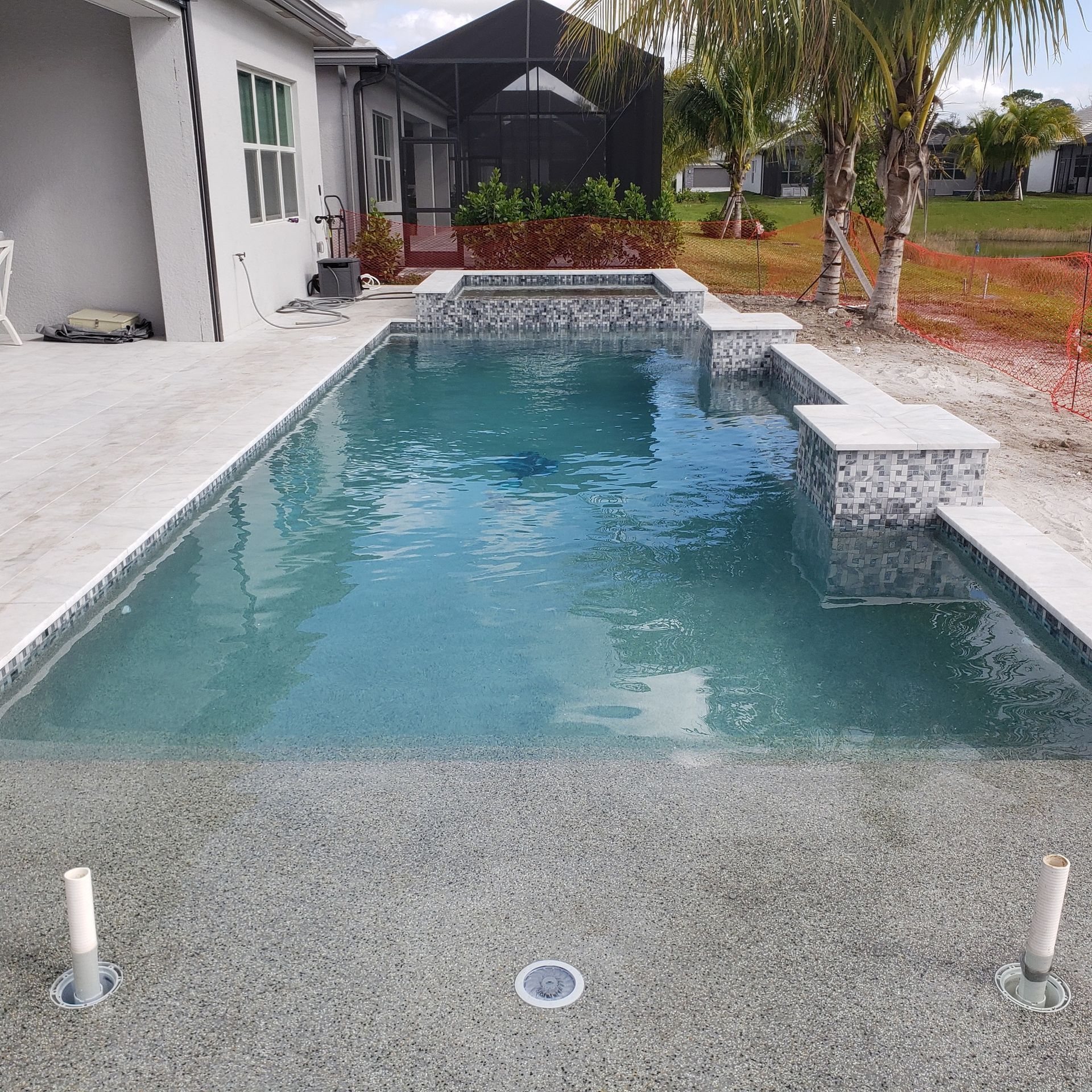 A large swimming pool with a house in the background.