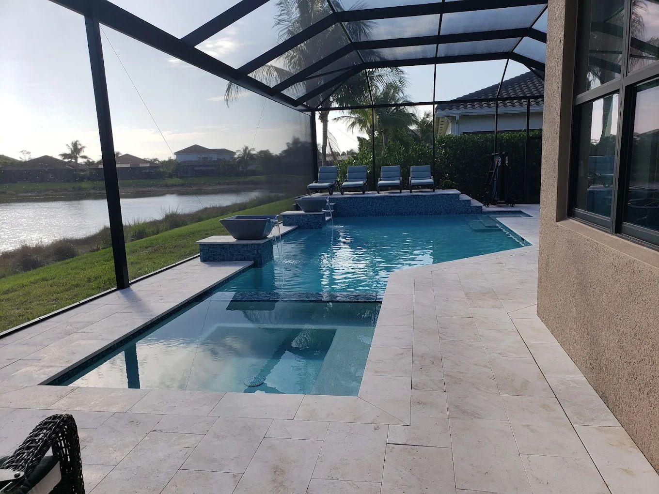 There is a large swimming pool in the backyard of a house.