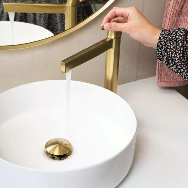 Woman Holding The Gold Tapware — Fixtures & Fittings In Tweed Heads South, NSW