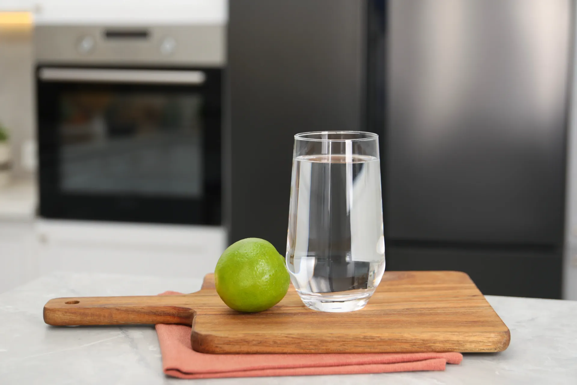 Glass of water and lime on a wooden board in a kitchen. — Fixtures & Fittings In Tweed Heads South, NSW