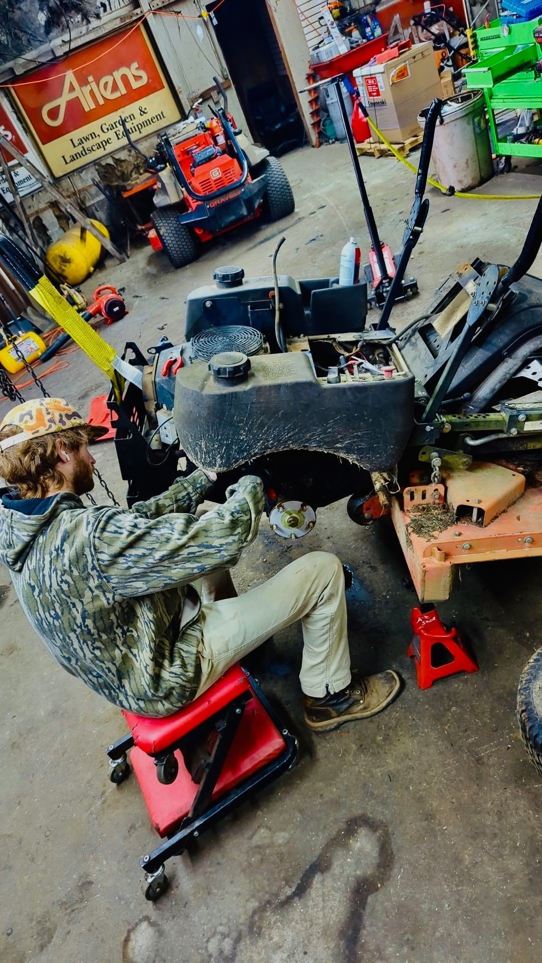Orange and white Stihl backpack leaf blower on a trailer, sunny day.