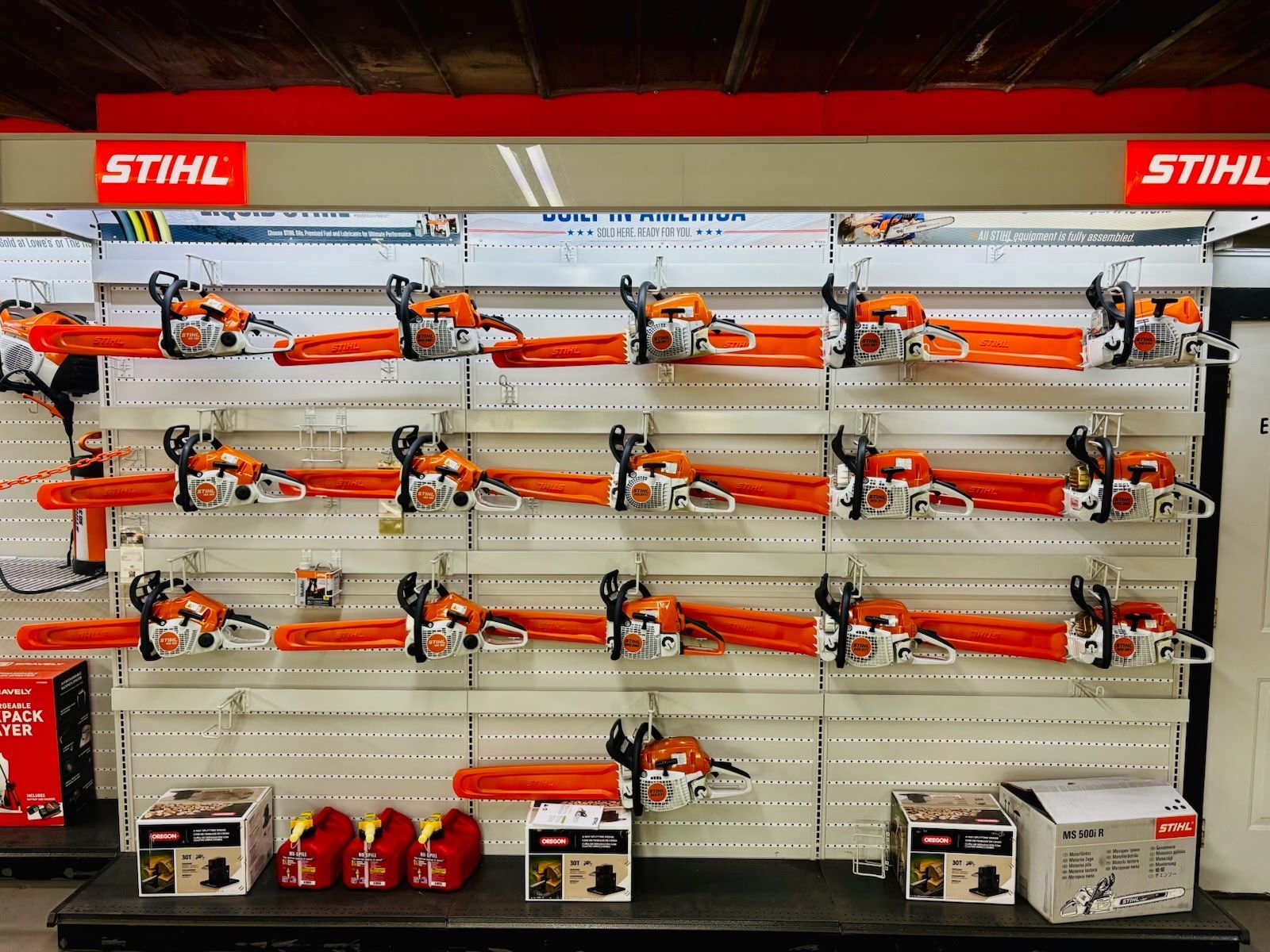 STIHL power tools displayed in a retail setting; shelves with equipment, orange and white branding.