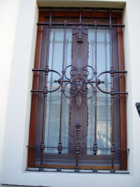 finestra in legno e vetro con inferriata