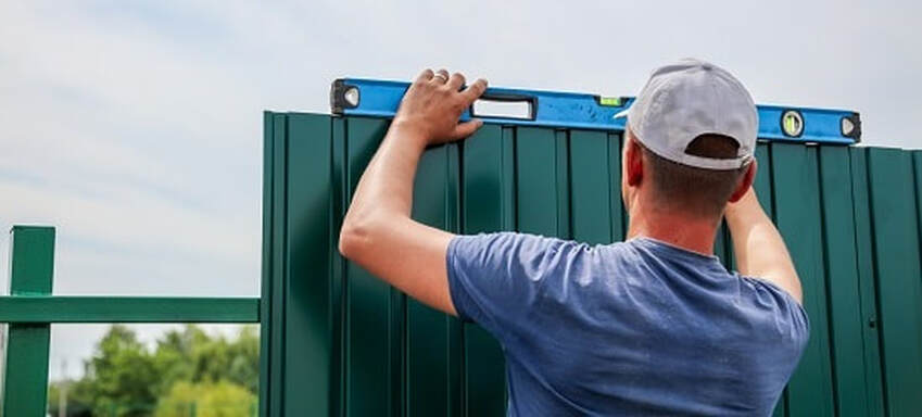 Professional fencer checking and making sure colorbond fences are installed correctly at Ballarat, Victoria.