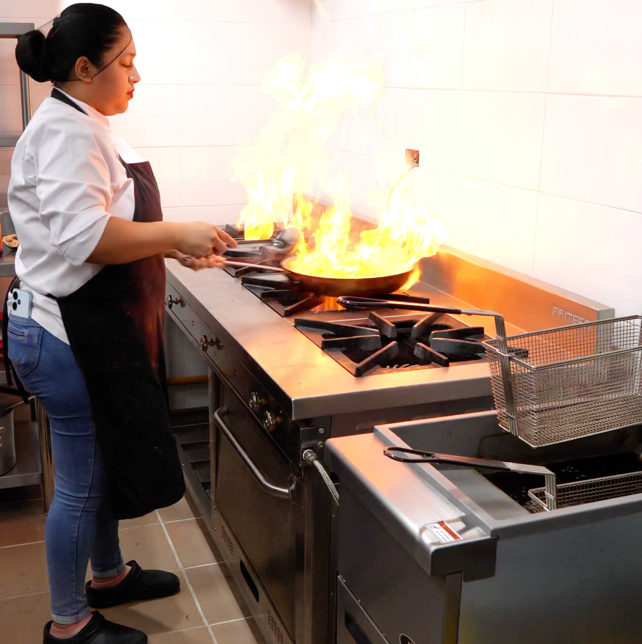 Una cocina con muchas ollas y sartenes en la encimera.