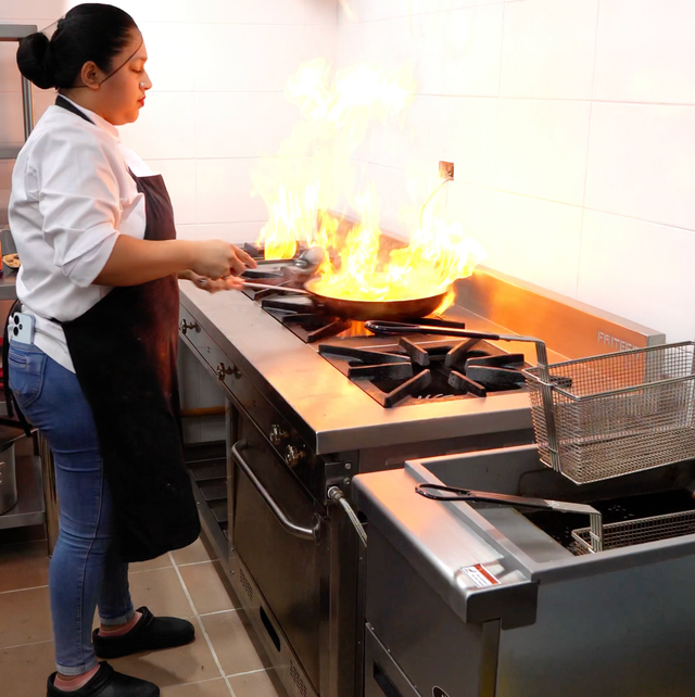 Una cocina con muchas ollas y sartenes en la encimera.