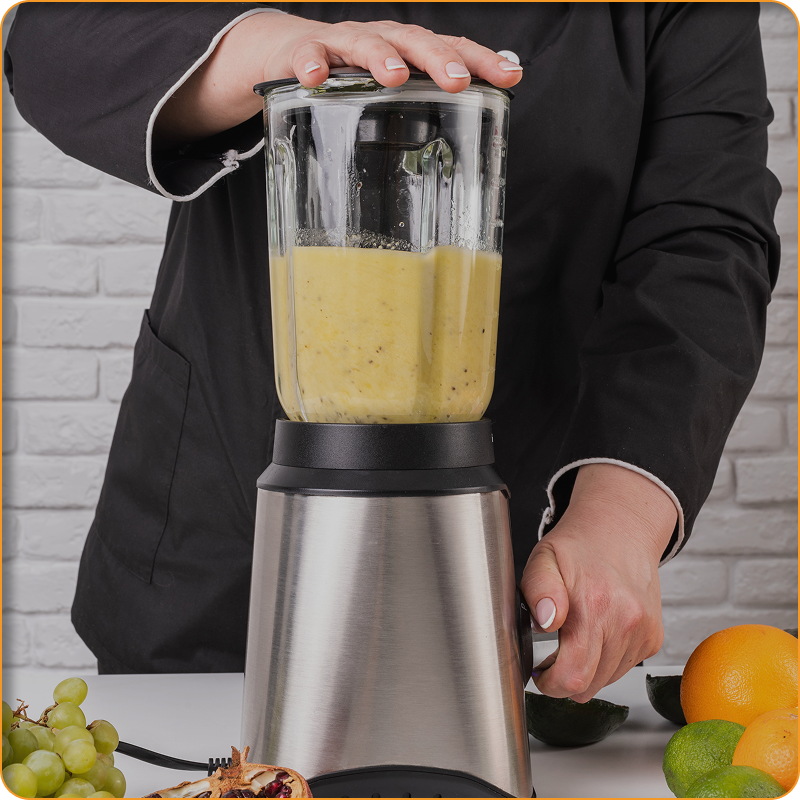 A person is using a blender to make a smoothie