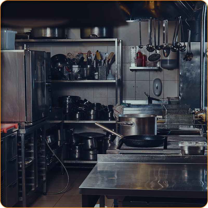 Una cocina con muchas ollas y sartenes en la encimera.
