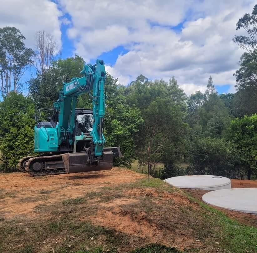 A blue excavator is sitting on top of a dirt hill. — Al's Excavation in Sunshine Coast, QLD