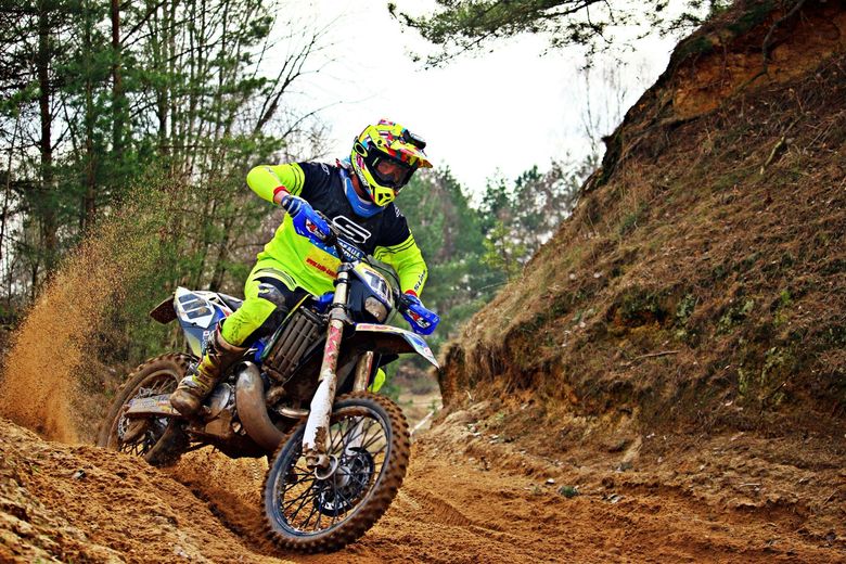A man is riding a dirt bike on a dirt road.