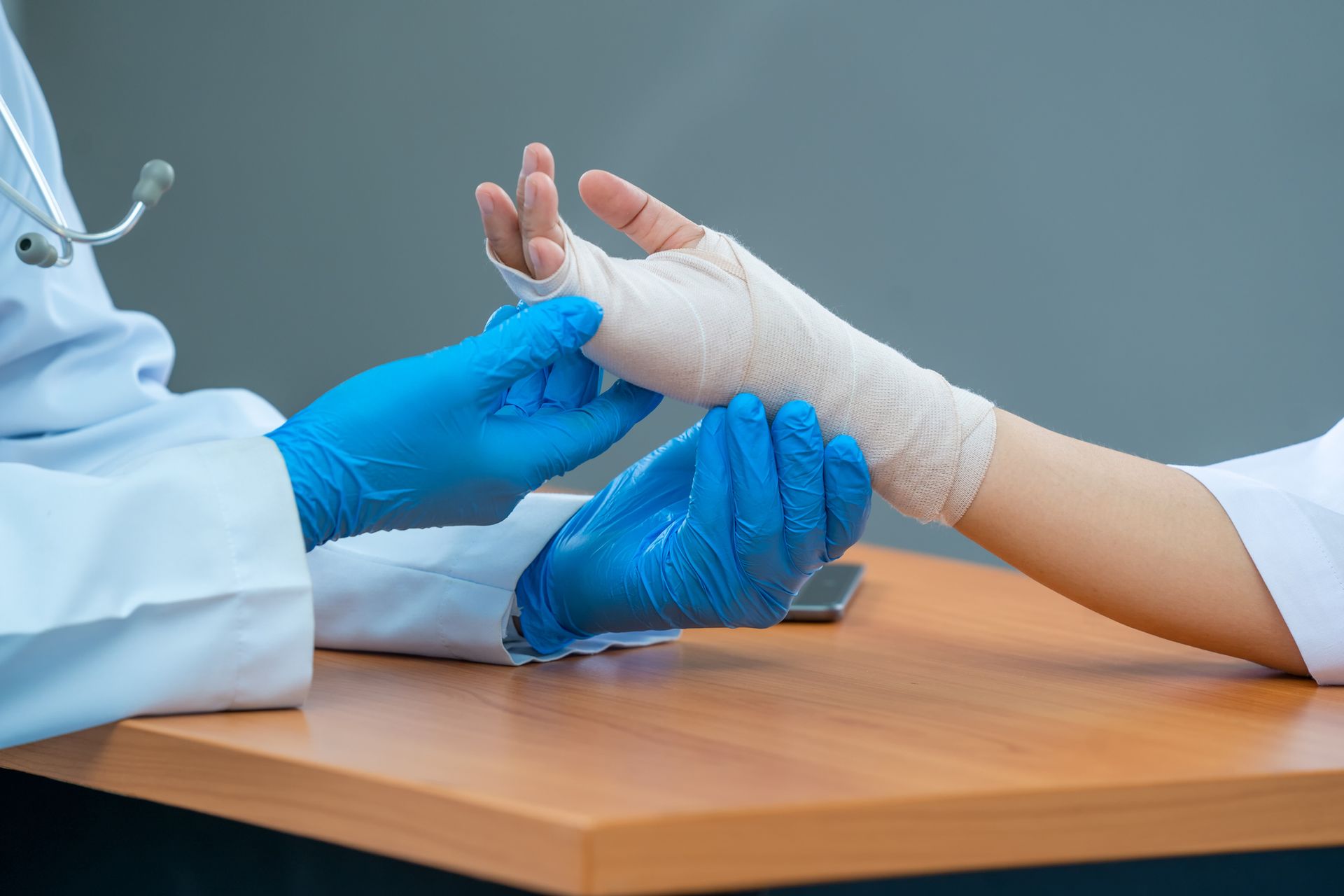 Doctor examining hand of patient.