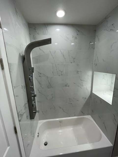 A bathroom with a bathtub and a shower.