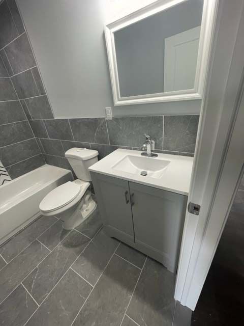 A bathroom with a toilet , sink , and mirror.