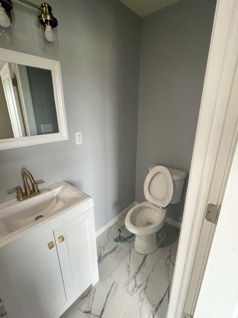 A bathroom with a sink , toilet and mirror.