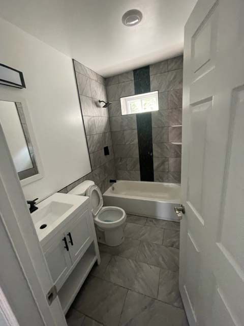 A bathroom with a toilet , sink , and bathtub.