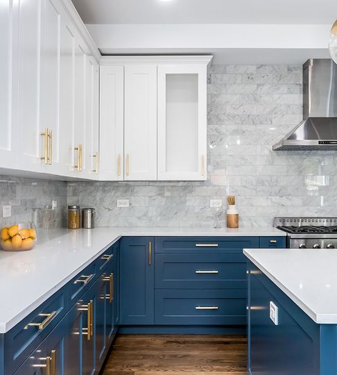 A kitchen with blue cabinets and white counter tops
