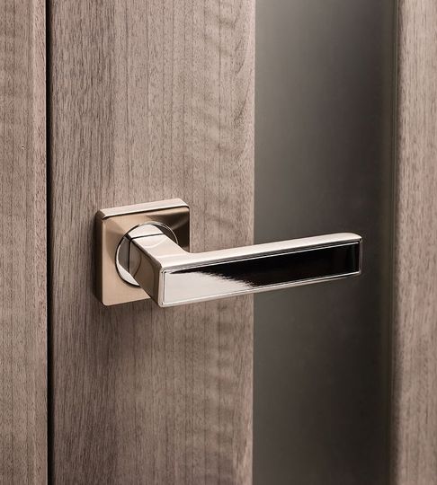 A close up of a door handle on a wooden door.