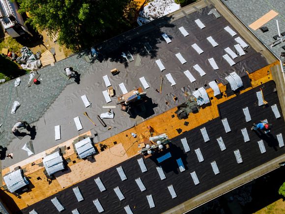 Workers Repairing Roof Aerial View