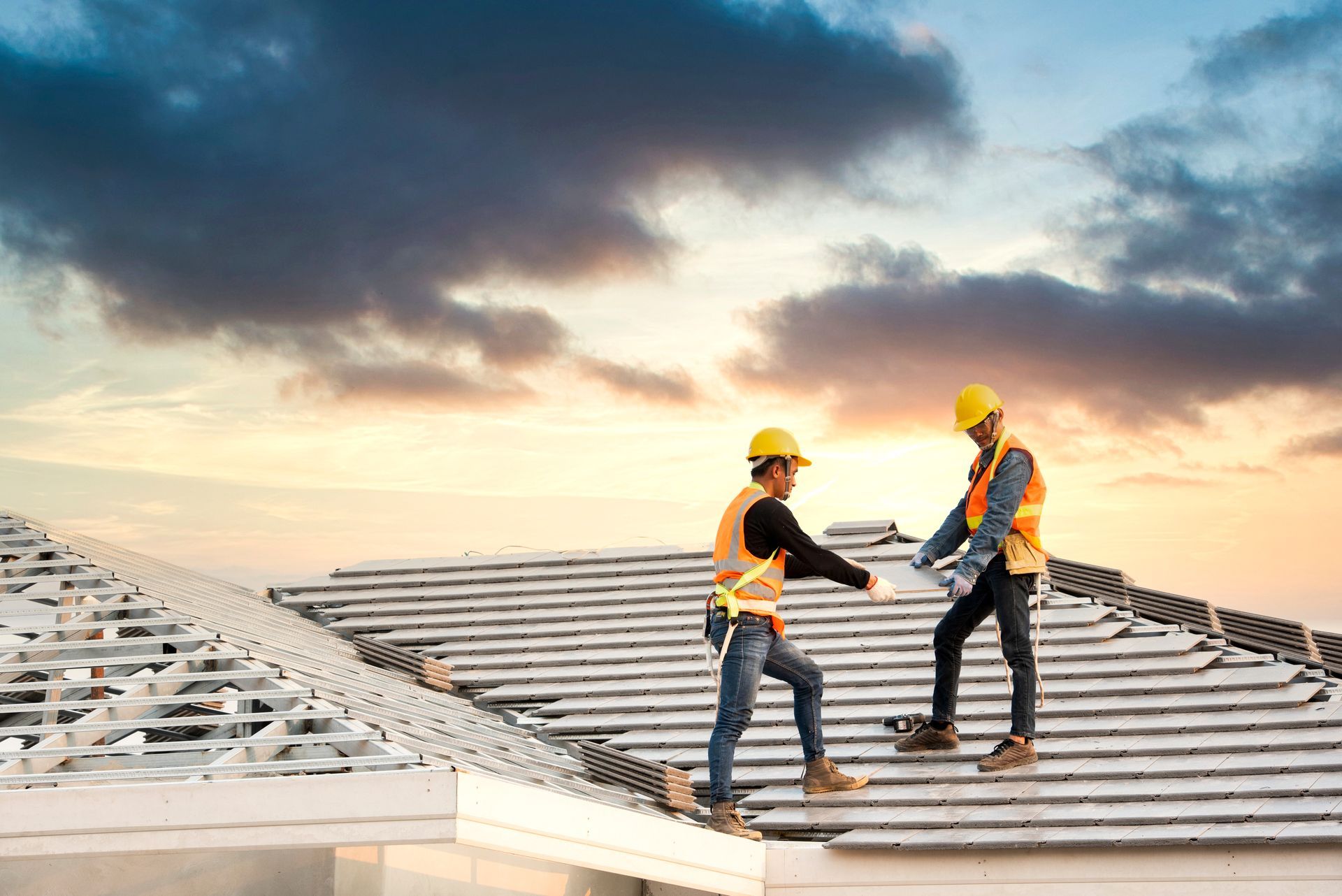 Two Workers Installing Roof Under Cloudy Sky Two Workers Installing Roof Under Cloudy Sky