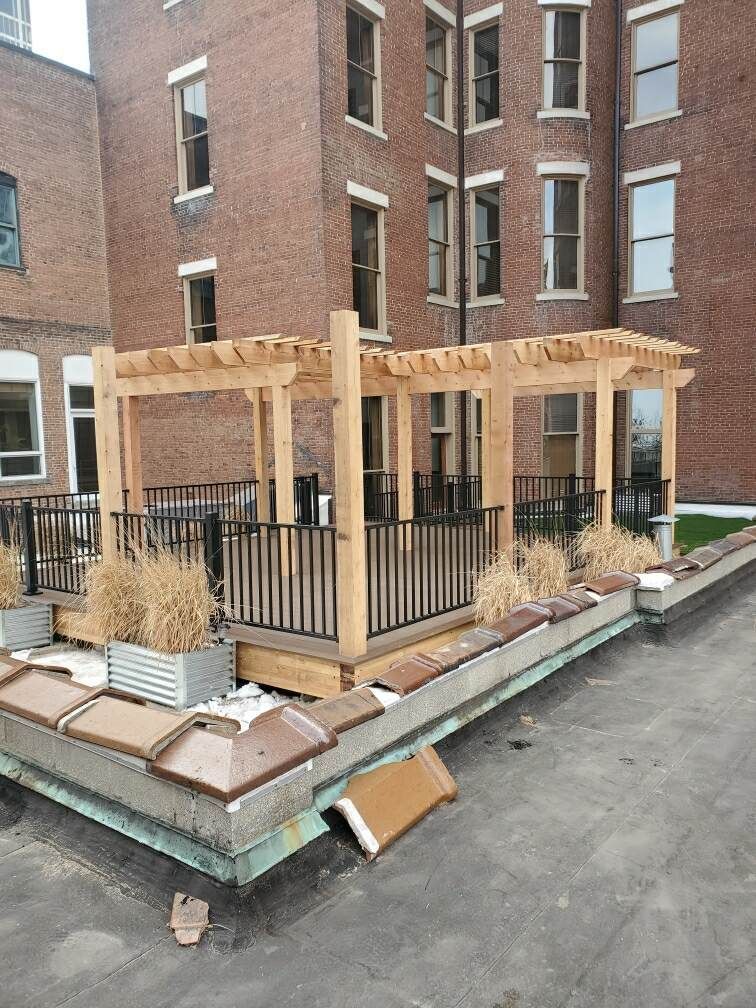 A wooden pergola is being built on the roof of a building.