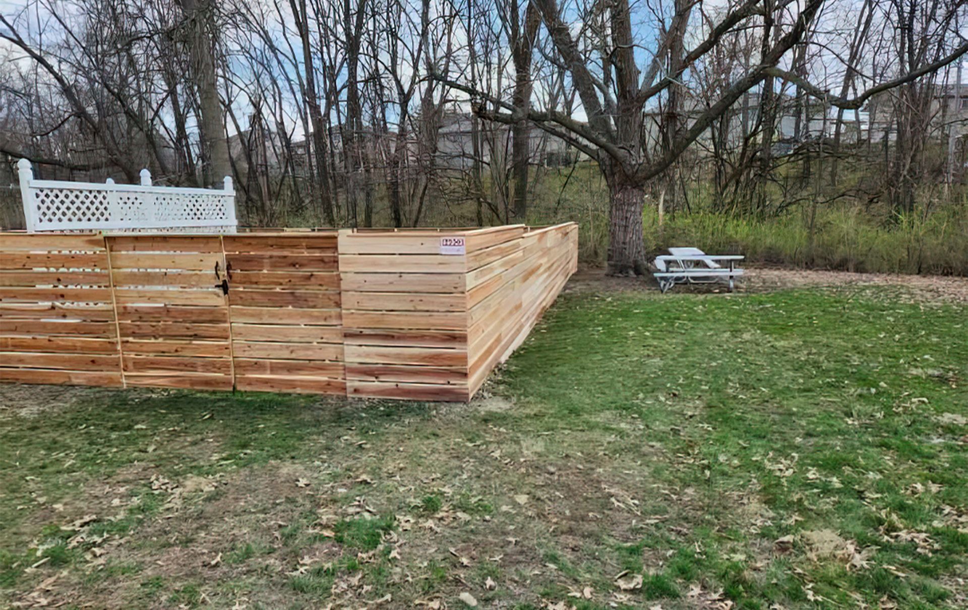 A wooden fence is sitting in the middle of a lush green field.