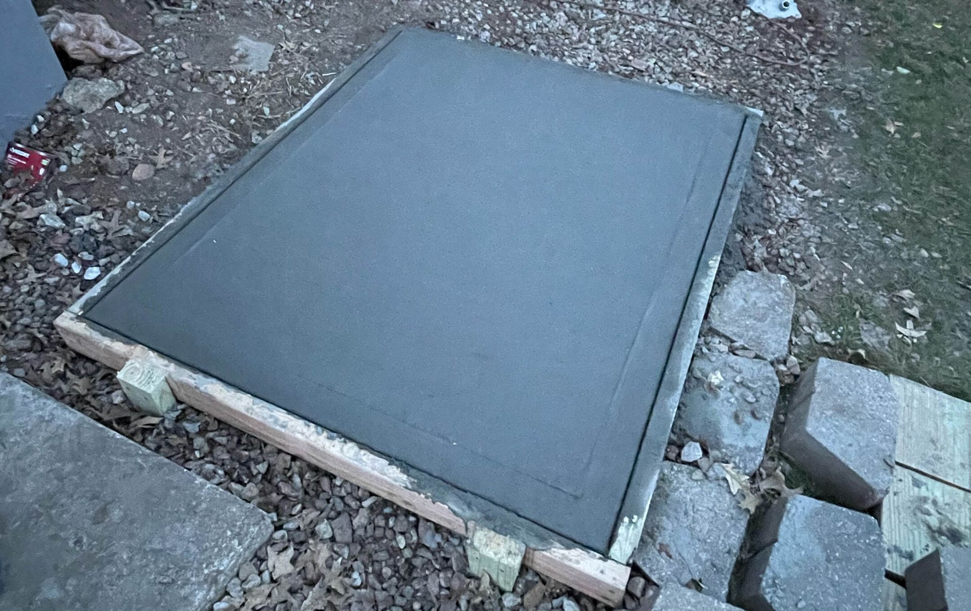 A large piece of concrete is sitting on top of a wooden frame.