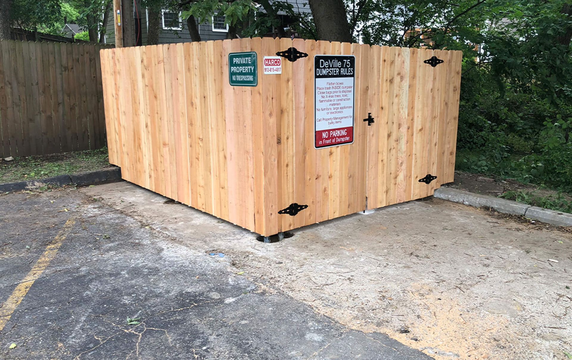 A wooden fence is sitting in the middle of a parking lot.