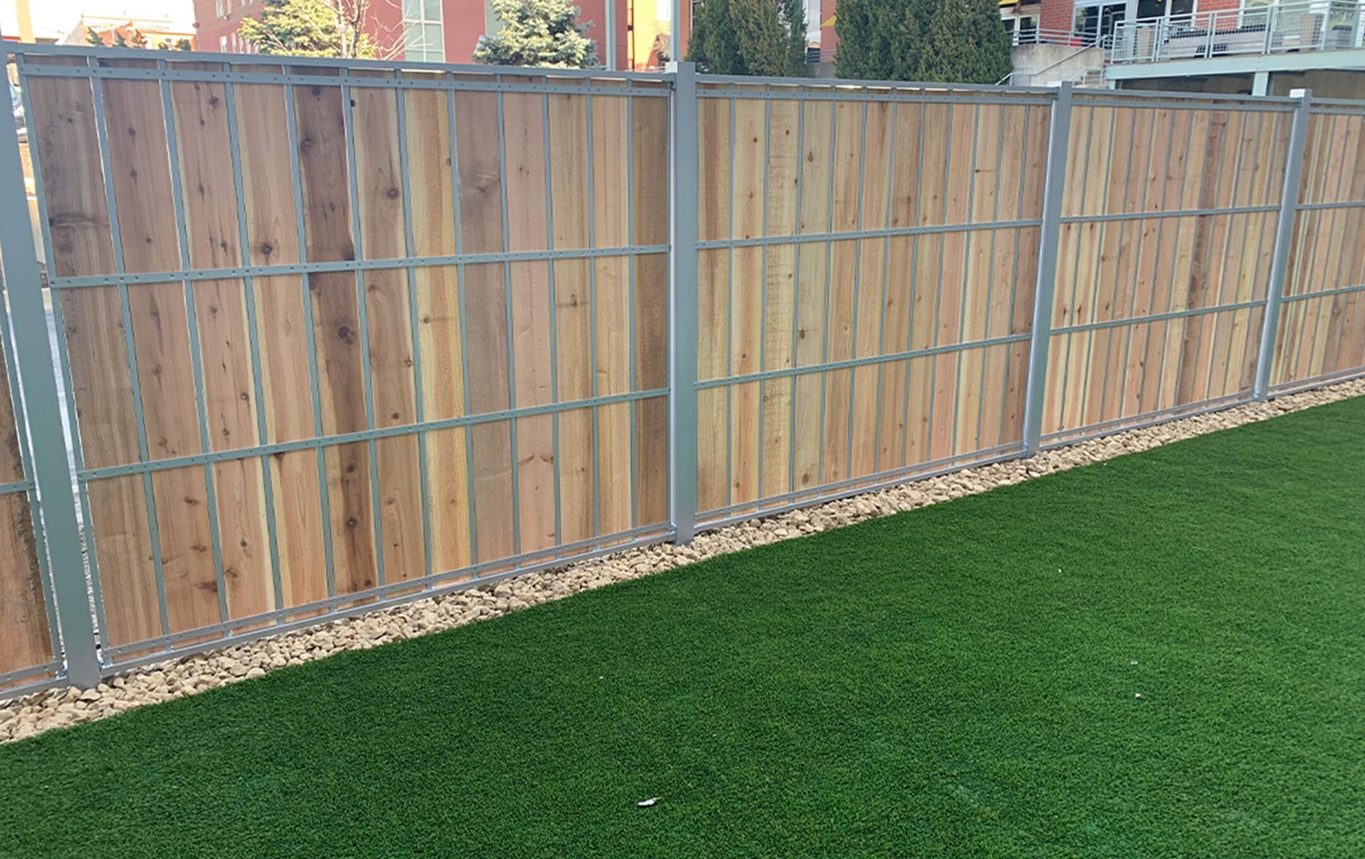 A wooden fence surrounds a lush green lawn.
