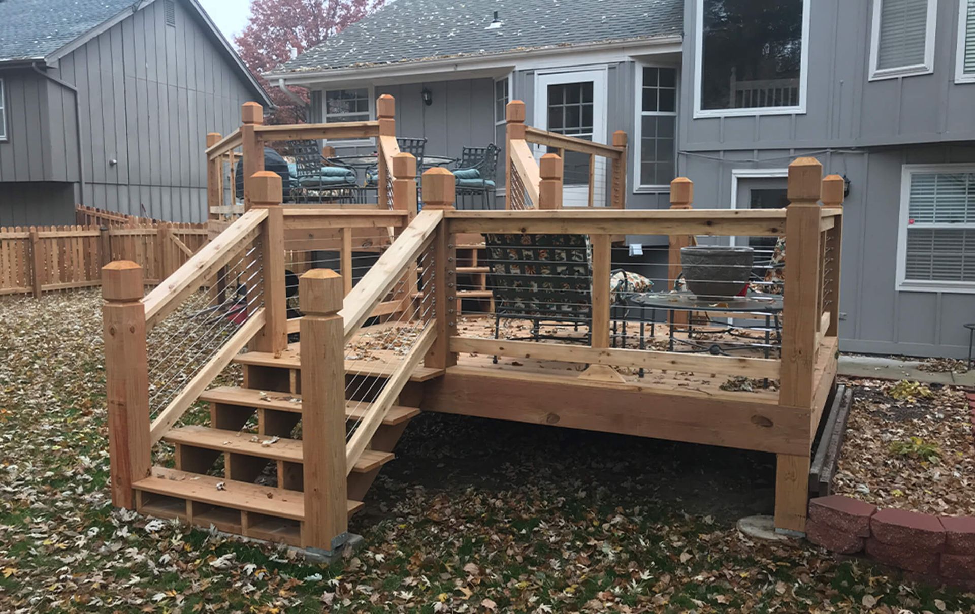 A wooden deck with stairs in front of a house
