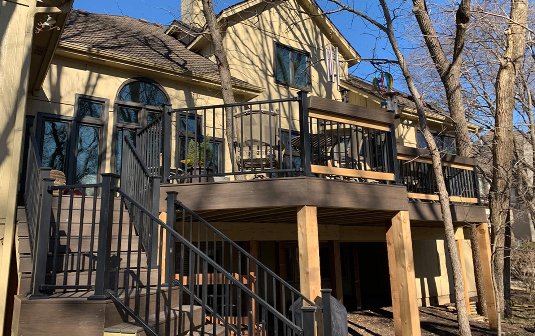 A large house with a large deck and stairs leading up to it.