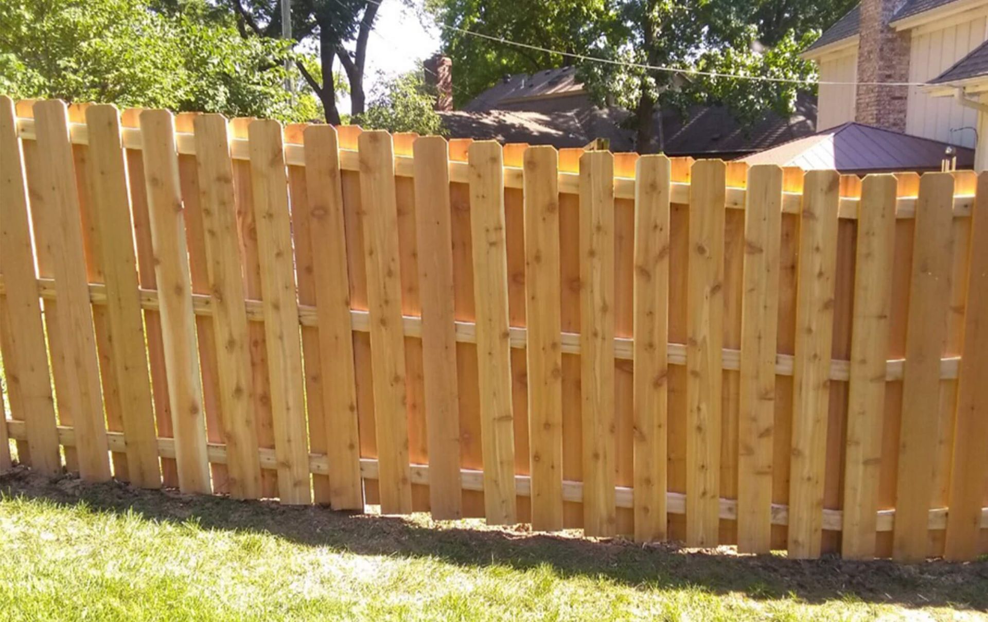A wooden fence with a house in the background