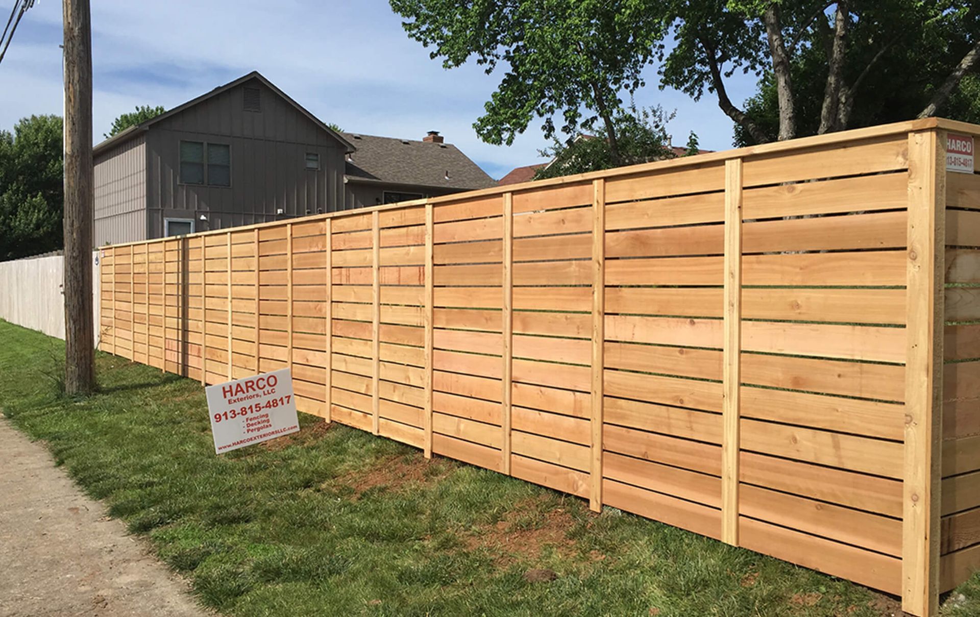 A wooden fence with a sign in front of it that says no parking.