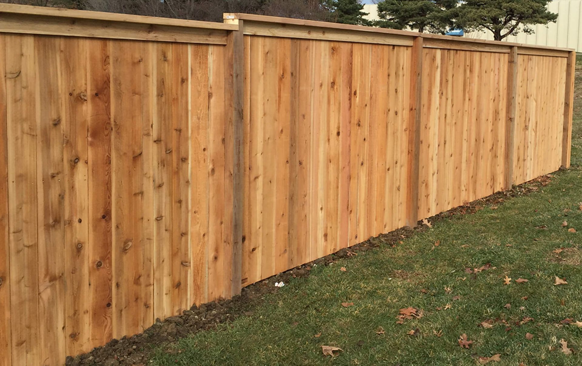 A wooden fence is sitting in the middle of a lush green field.