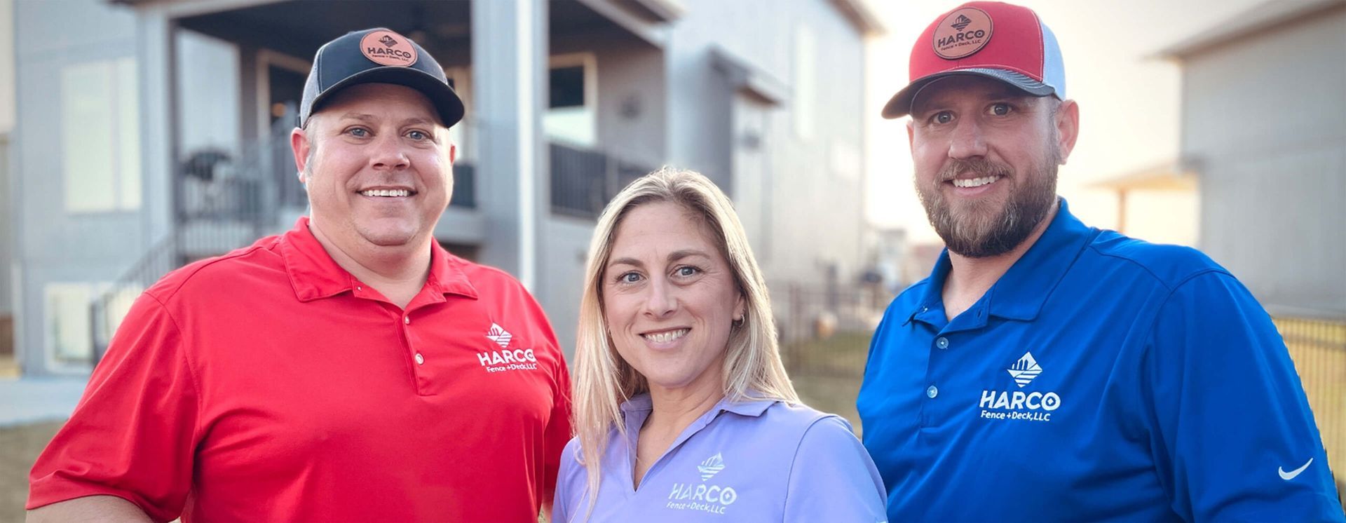 Three people are posing for a picture in front of a house.