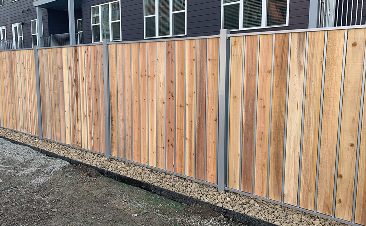 A black wrought iron fence surrounds a lush green hedge.