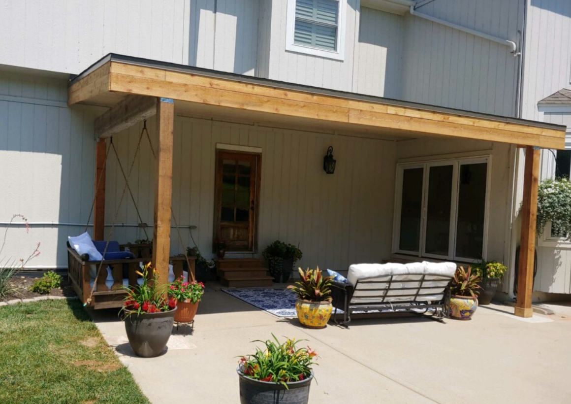 A man is hammering a nail into a wooden deck.