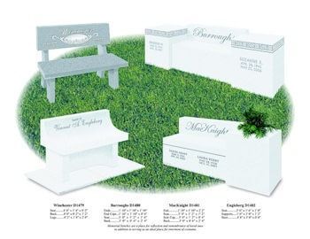 A group of white benches are sitting on top of a lush green field.
