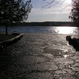 A person is standing on a dock next to a lake