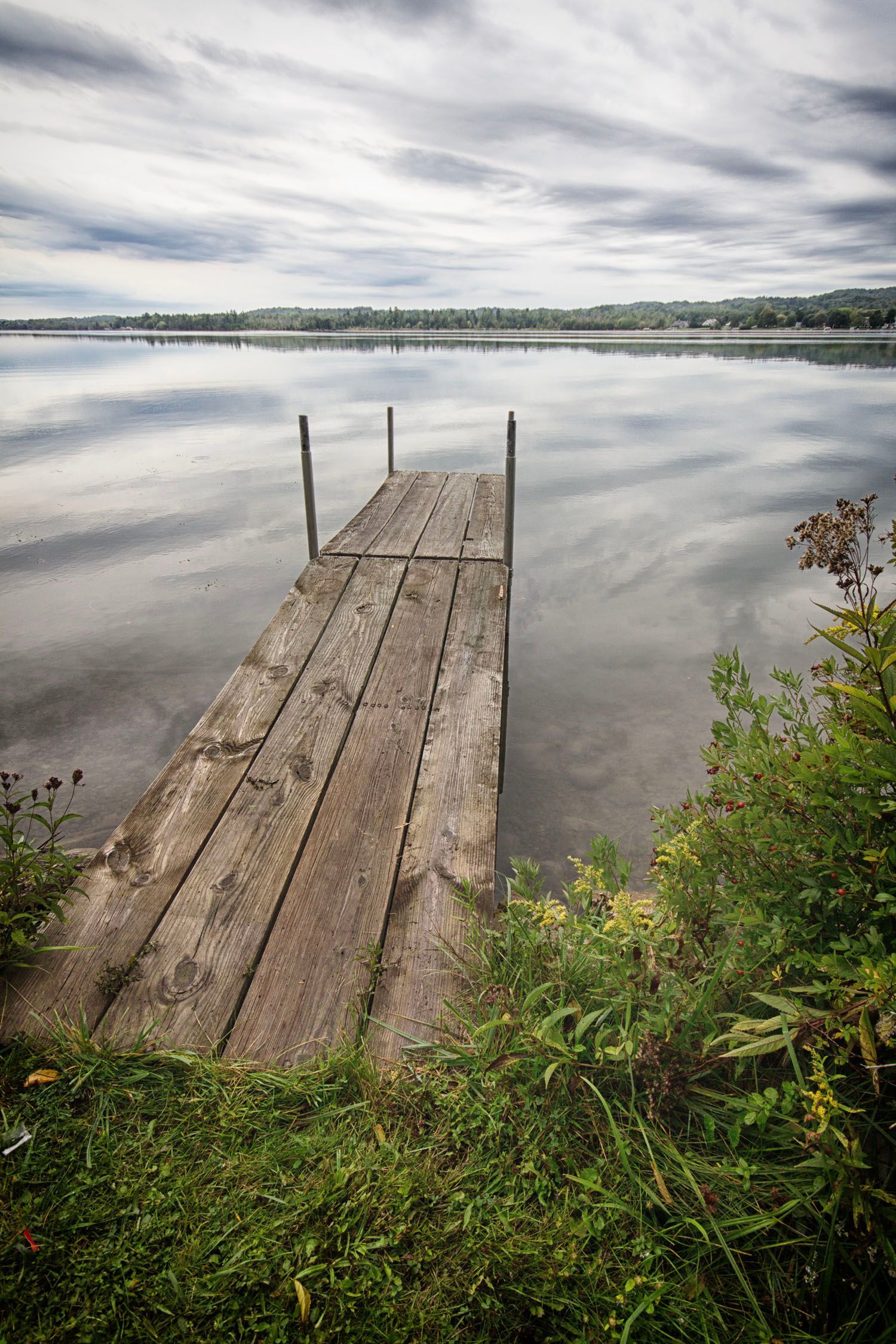 There is a wooden dock in the middle of a lake
