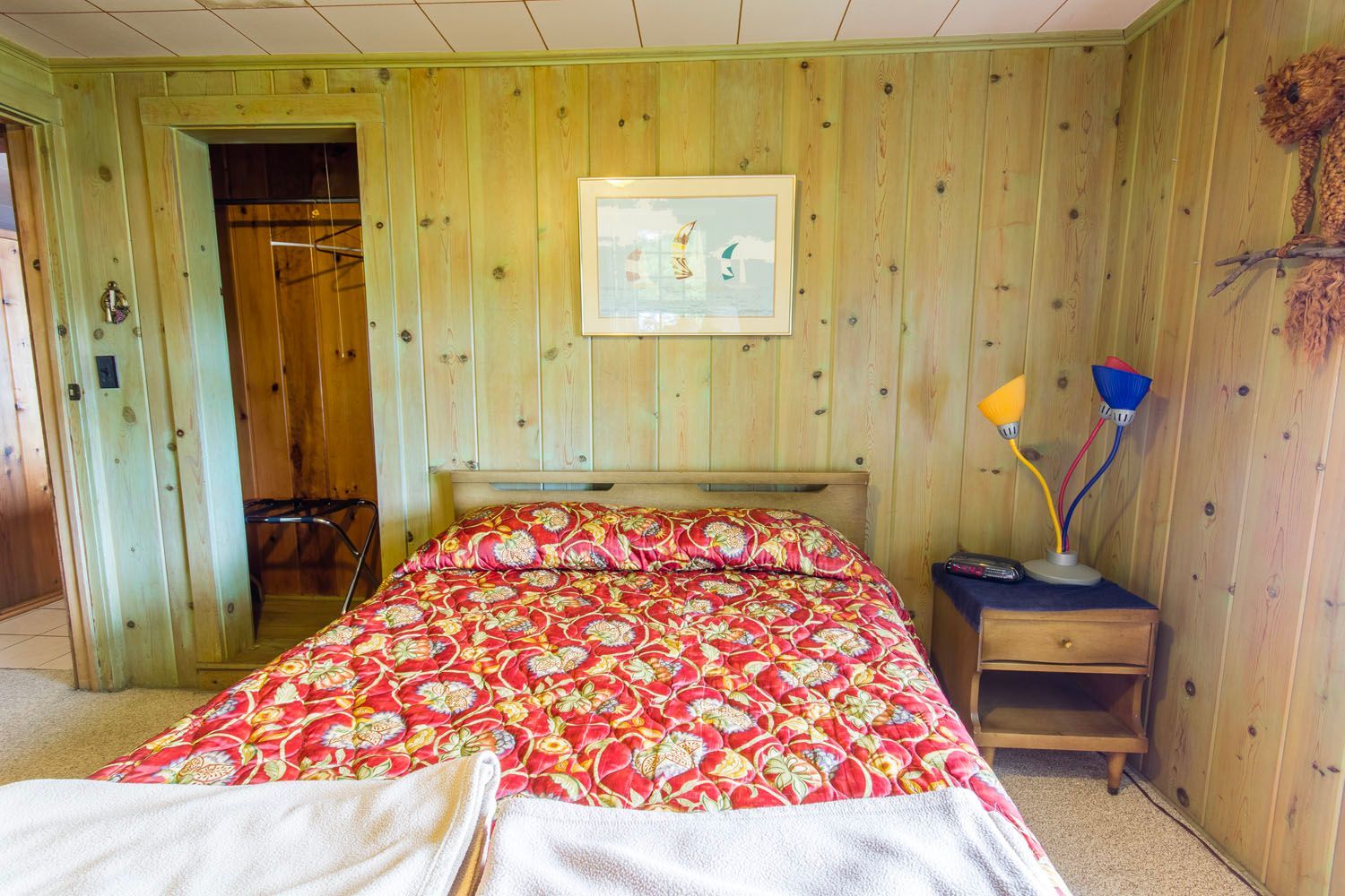 A bedroom with a bed , nightstand and lamp