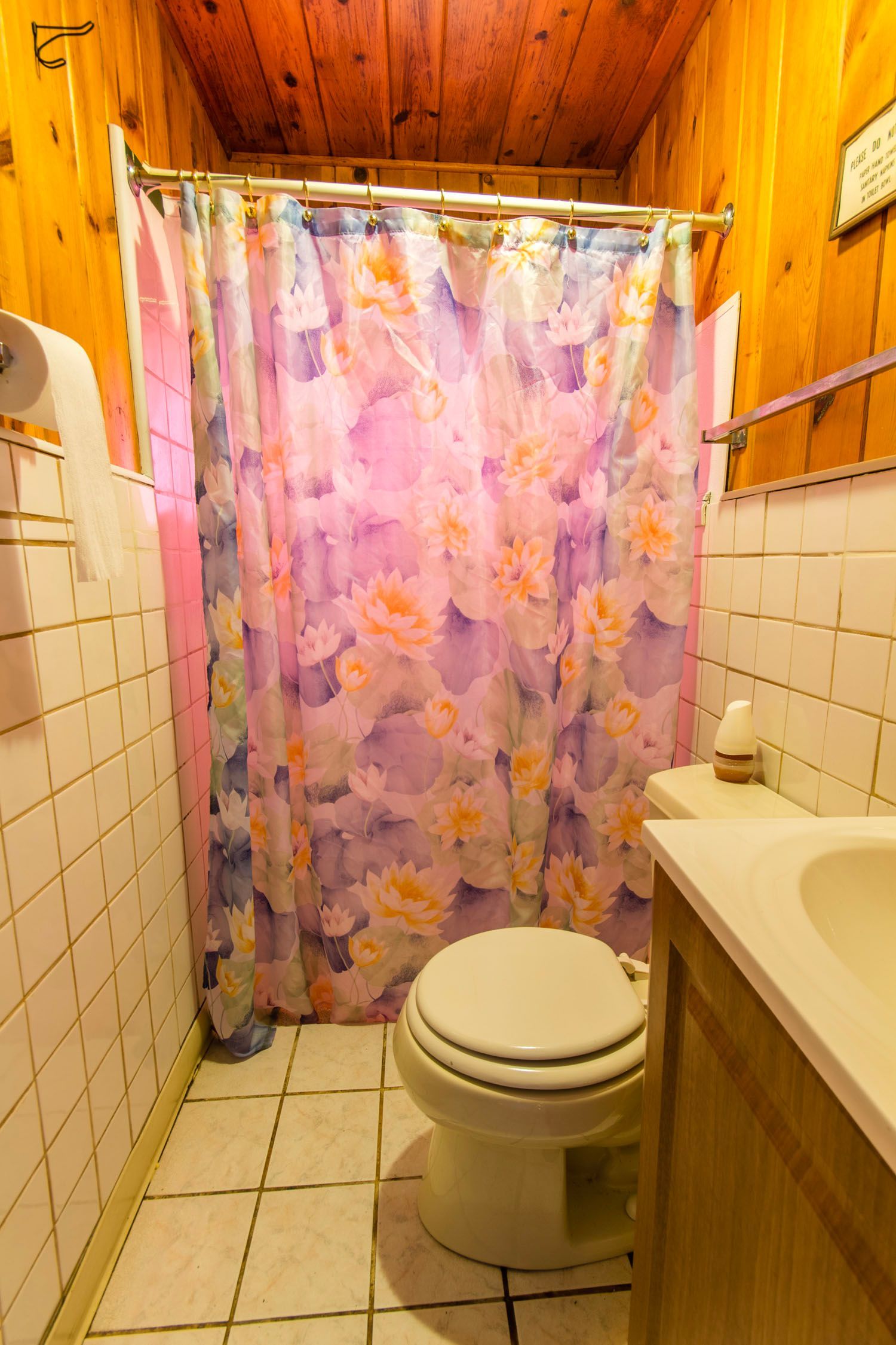 A bathroom with a toilet , sink and shower curtain