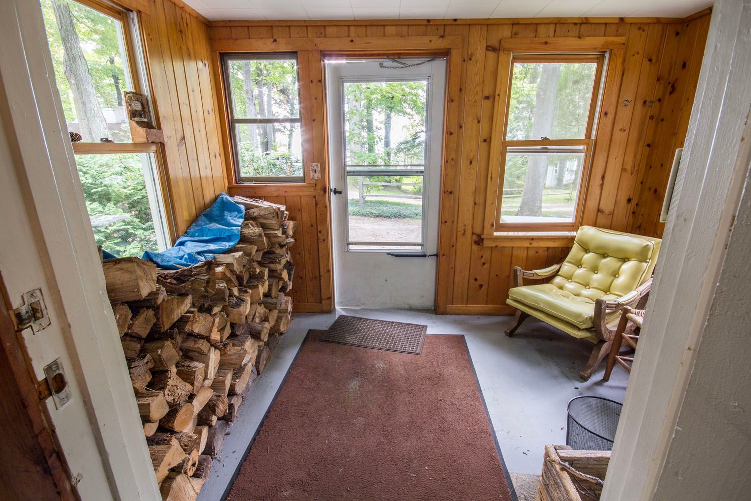 A room with wooden walls , a chair , and a door