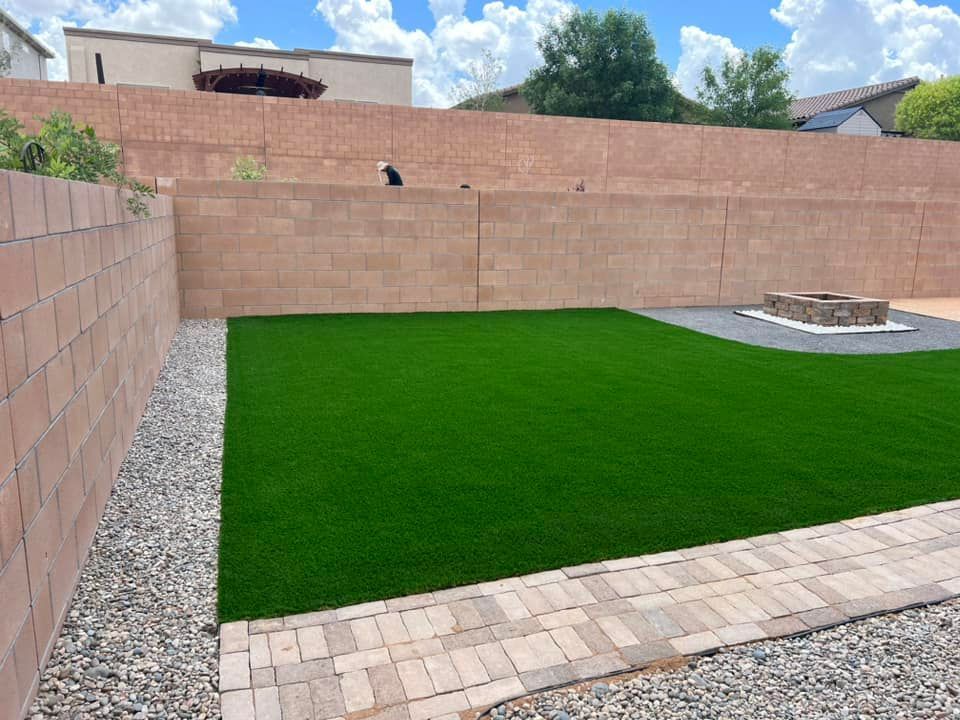 A backyard with a brick wall and a fire pit